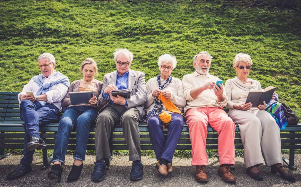seniors assis sur un banc avec technologie